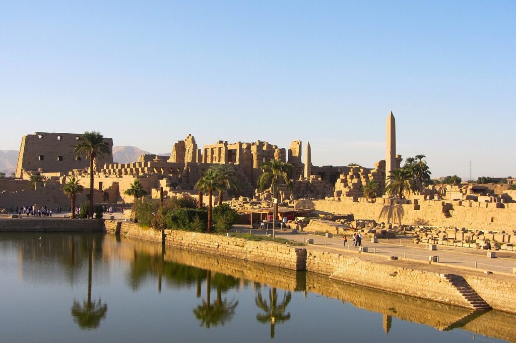 View of the Sacred Lake and surrounding structures at the Karnak Temple Complex in Luxor, Egypt.