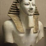 Upper portion of a statue of Pharaoh Thutmose III wearing the Nemes headdress and Uraeus, symbolizing his royal authority.