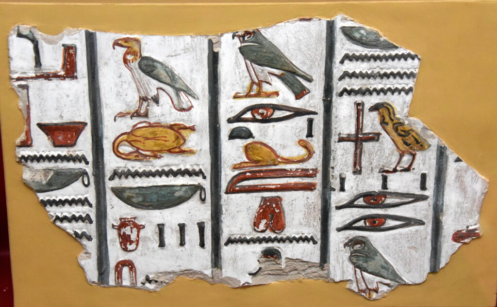 "Fragment of ancient Egyptian hieroglyphs carved in stone, showing pictorial symbols once used for sacred and monumental writing."
